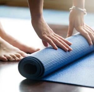 Woman folding mat after yoga