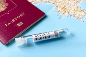 COVID-19, travel and test concept, tube for PCR testing and tourist passport on geographic map. Coronavirus diagnostics in airport due to pandemic. Tourism and business hit by SARS-Cov-2 corona virus