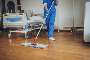 A woman is mopping the floor in the hospital ward at the medical center.