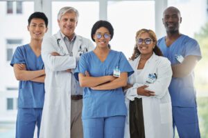 Portrait of a group of FAMILY medical practitioners standing together with their arms crossed in a hospital